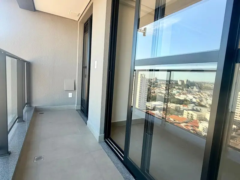 Varanda com porta de vidro e vista da cidade